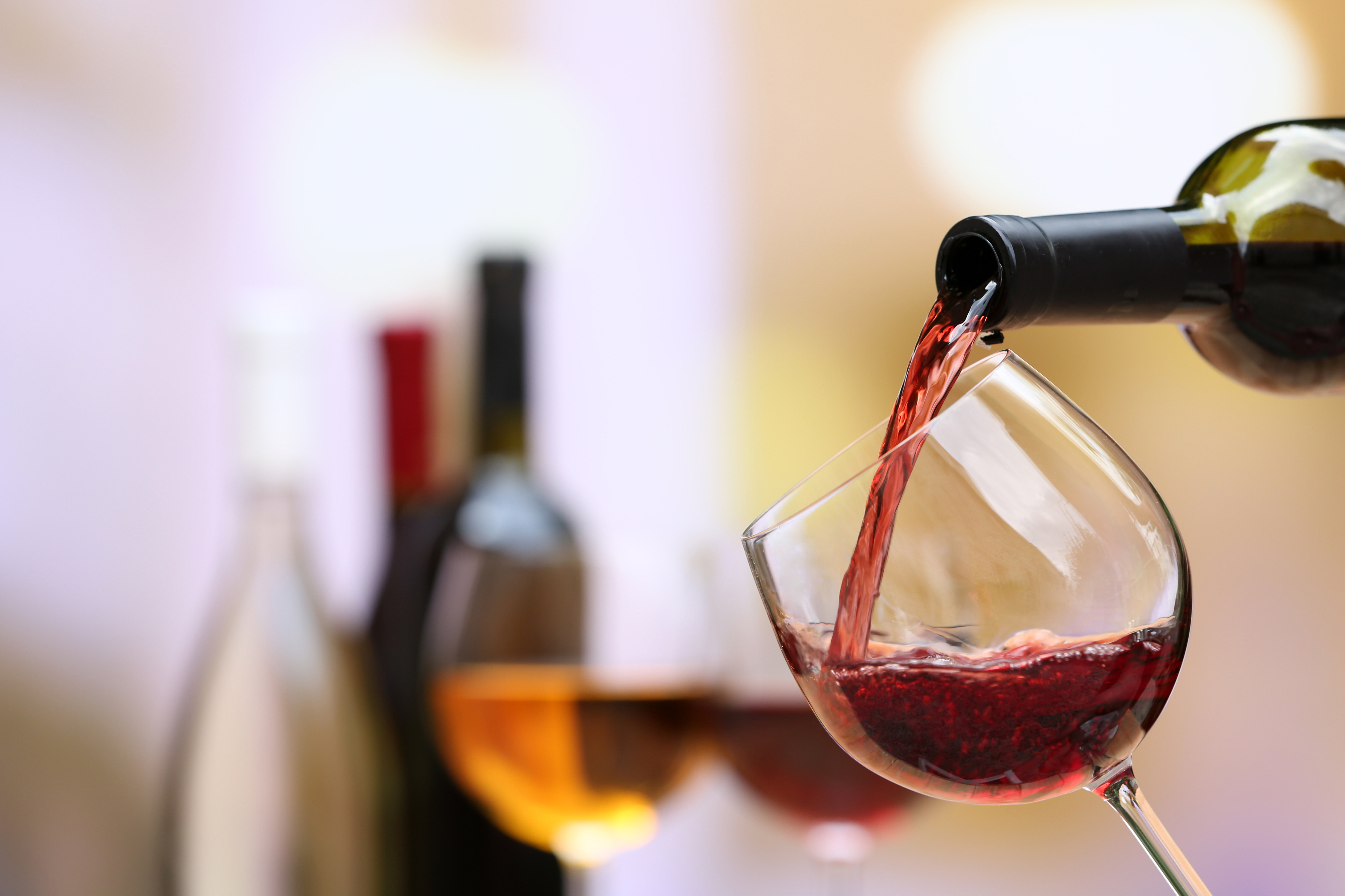 Red wine pouring into wine glass, close-up