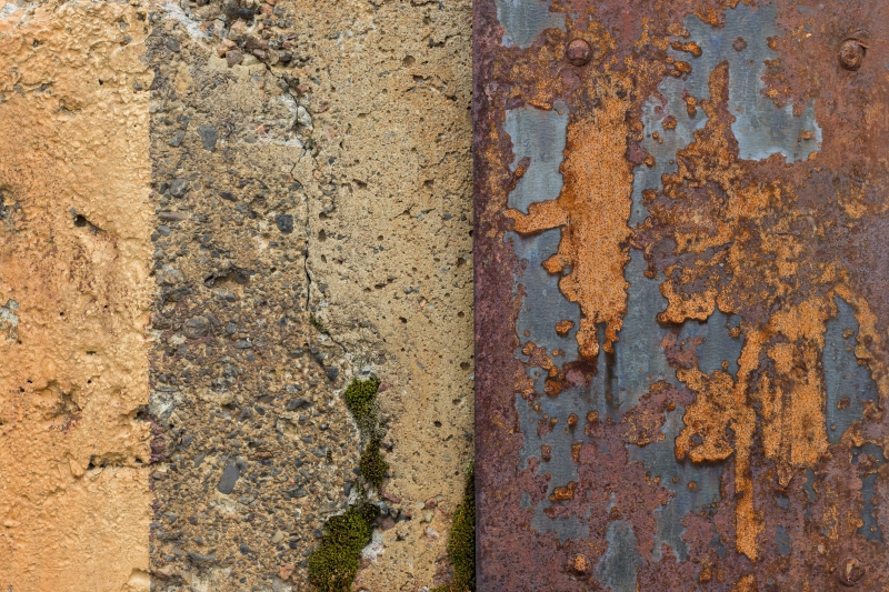 concrete wall and a ragged and rusty sheet metal plate